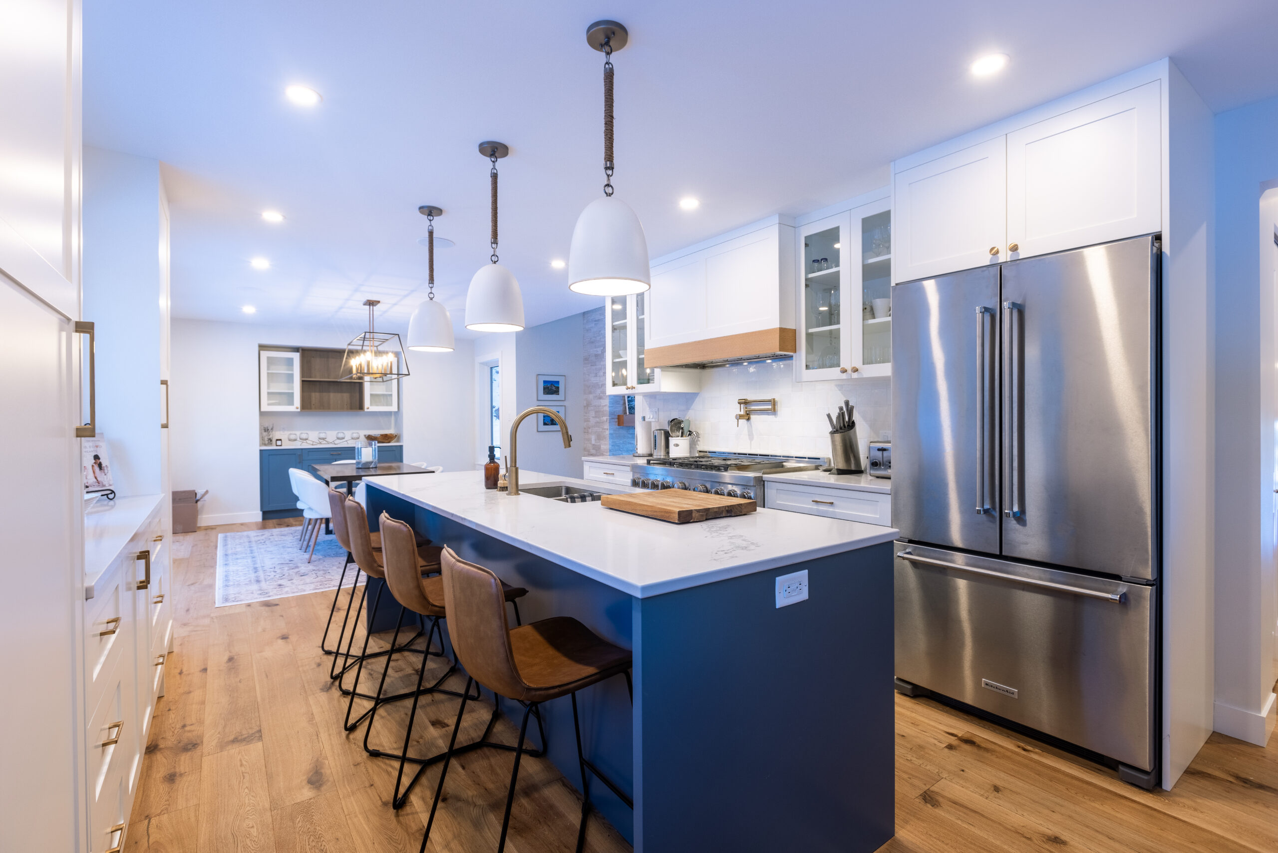 Kitchen at the Greenwood Way whole-home renovation, with a blue island and white cabinetry.