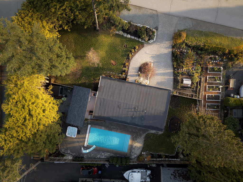 Aerial view of the Kintyre home, pool, outdoor spaces and surrounding trees.